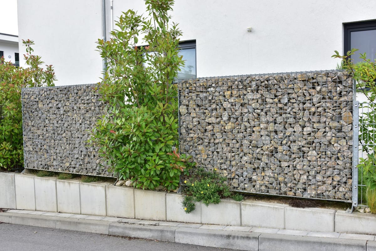 Clôture en gabions remplis de pierres le long d'une propriété