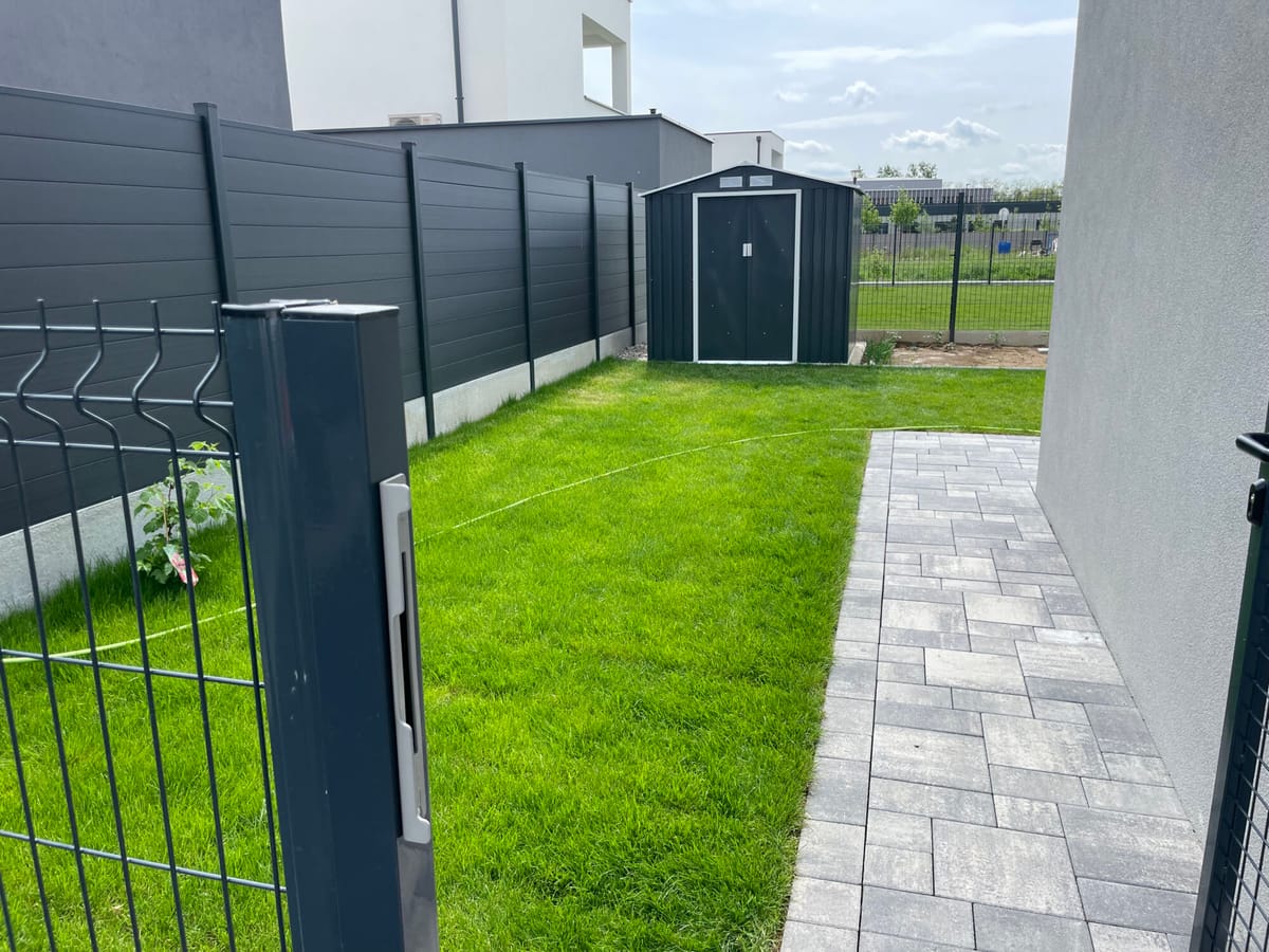 Clôture occultante et abri de jardin sur une parcelle engazonnée