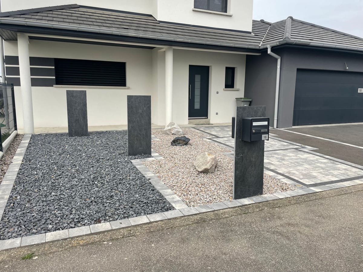 Cour en pavés et graviers décoratifs devant un garage double