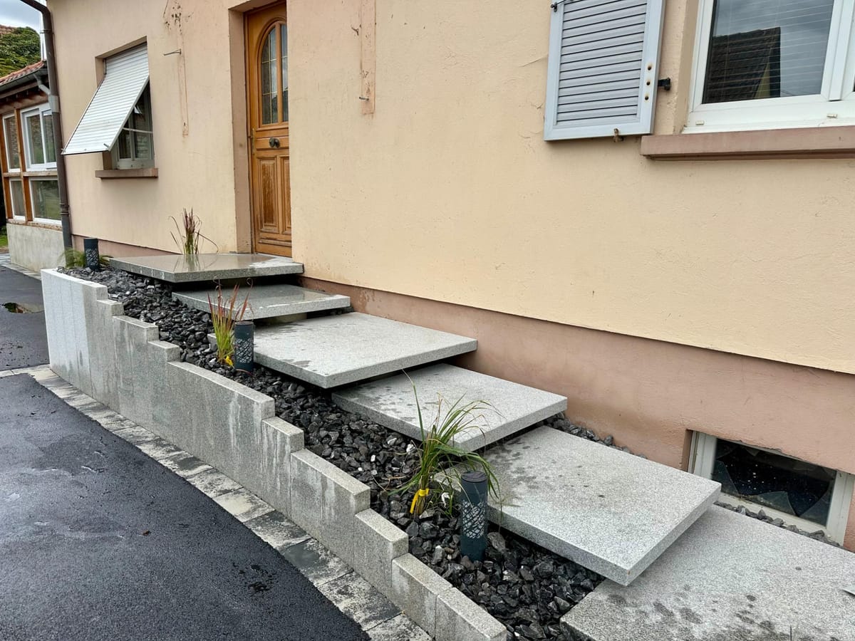 Escalier en blocs de pierre bordé d'un massif de graviers décoratifs