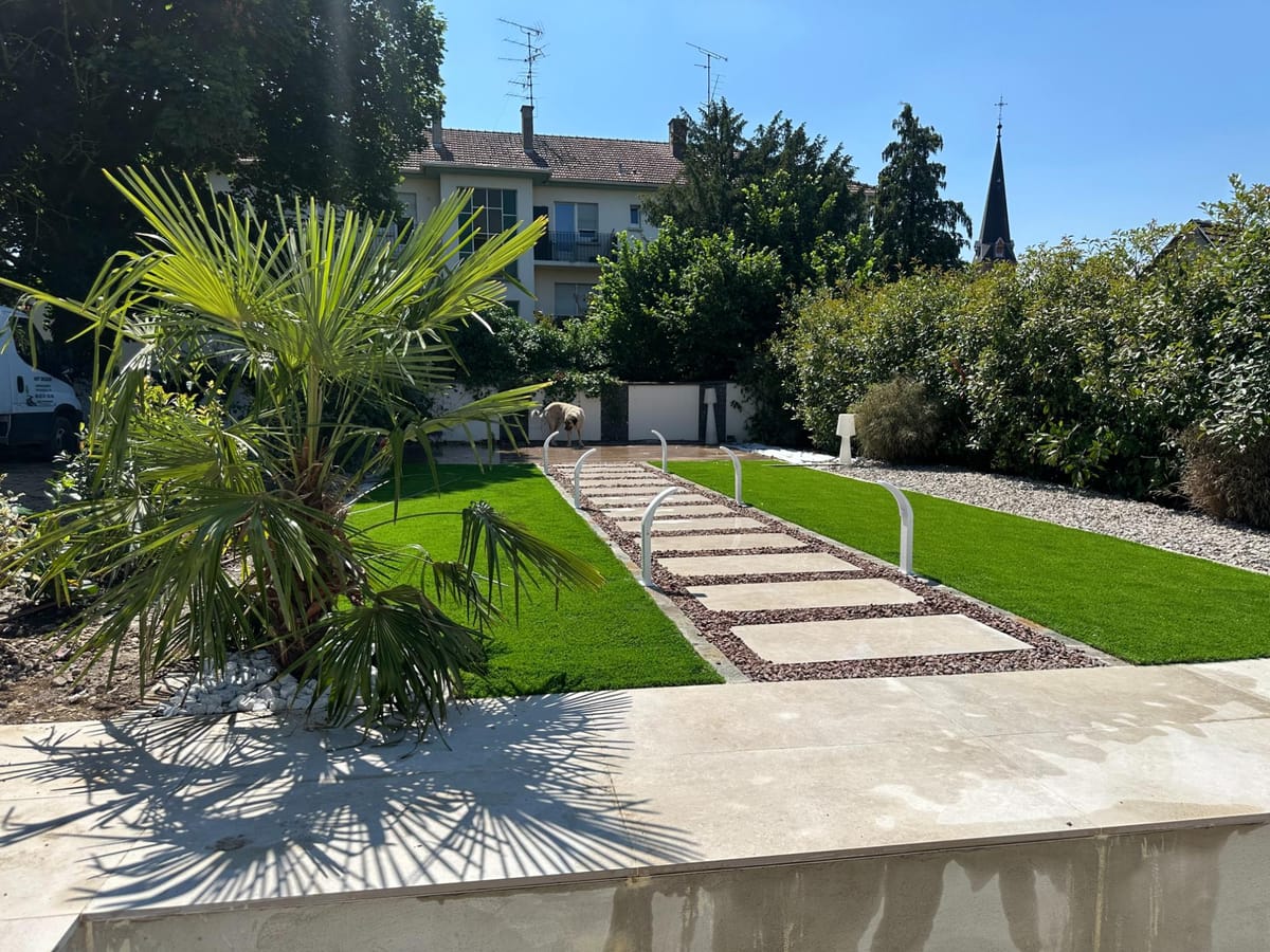 Jardin avec palmiers, gazon et cheminement en pas japonais