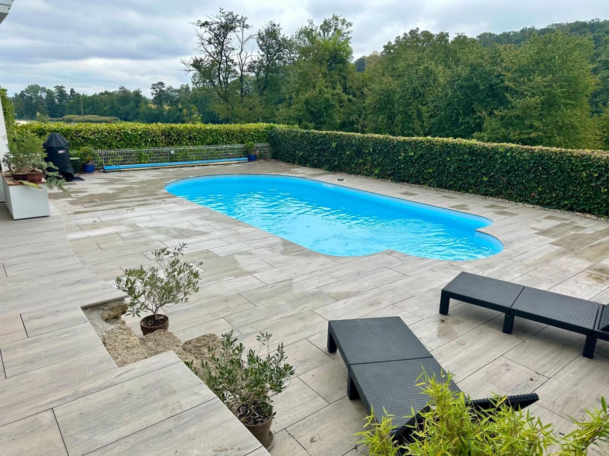 Piscine et terrasse en dalles avec bains de soleil, réalisation à Magstatt-le-Haut