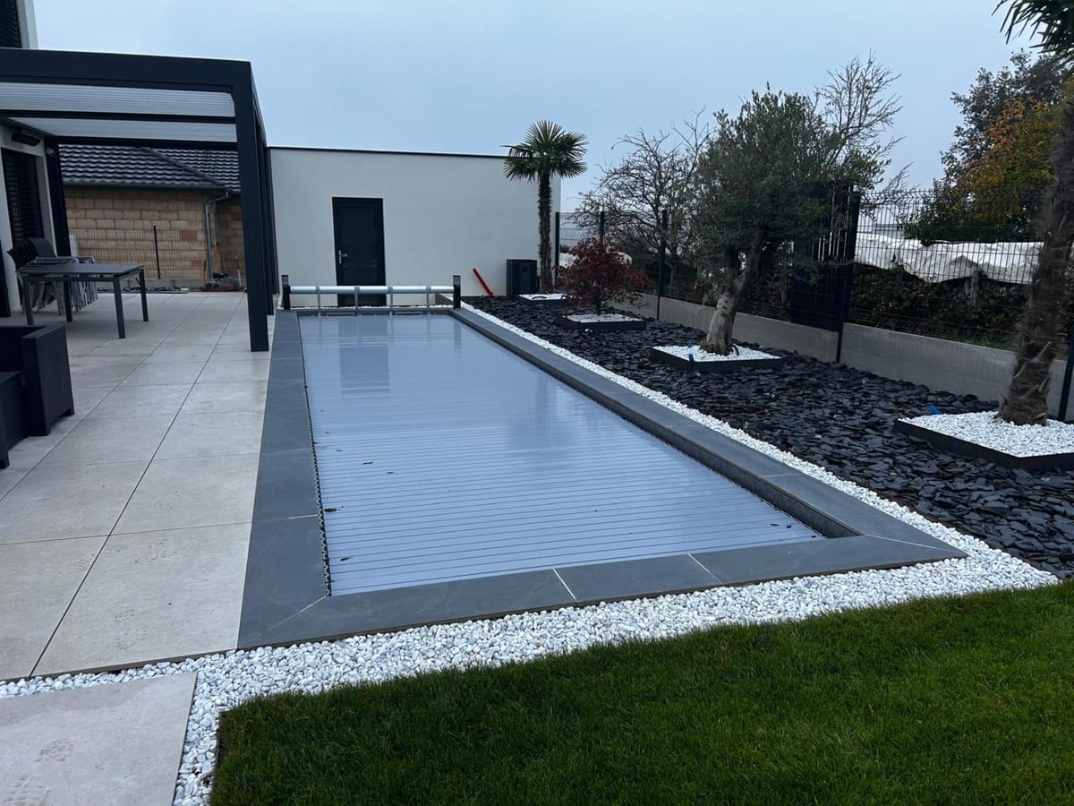 Couloir de nage avec plage en dalles grand format et bordures sombres