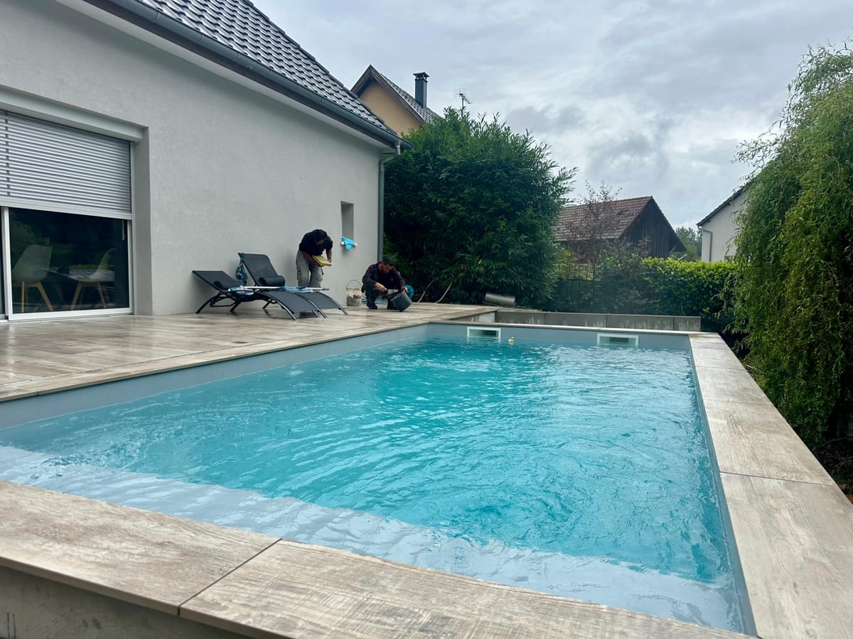 Piscine et terrasse en dalles devant une maison individuelle en Alsace