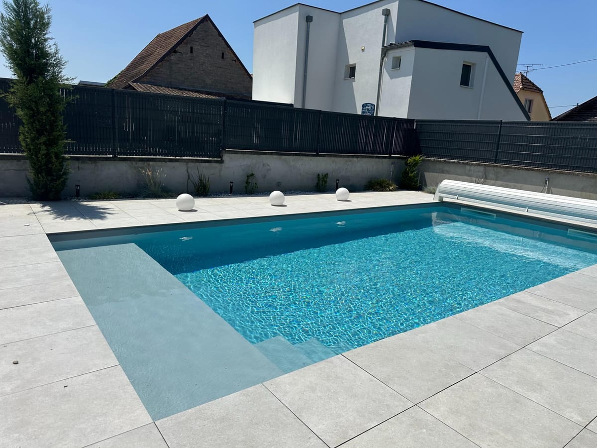 Piscine et terrasse protégées par une clôture occultante sombre
