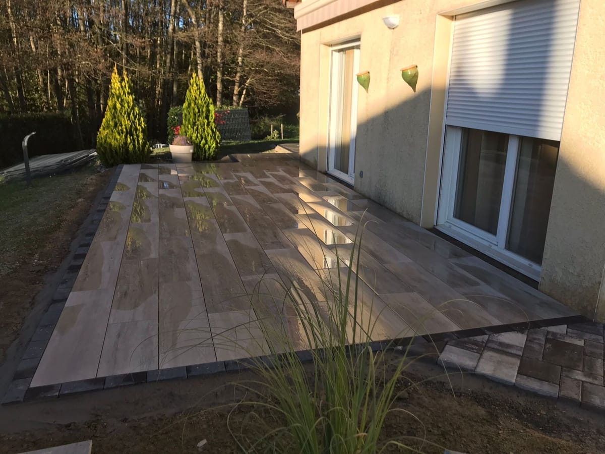 Terrasse en bois composite bordée de graminées ornementales
