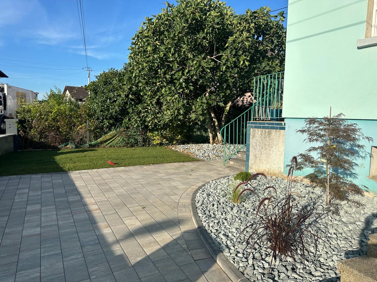Terrasse en dallage prolongée par une allée en enrobé