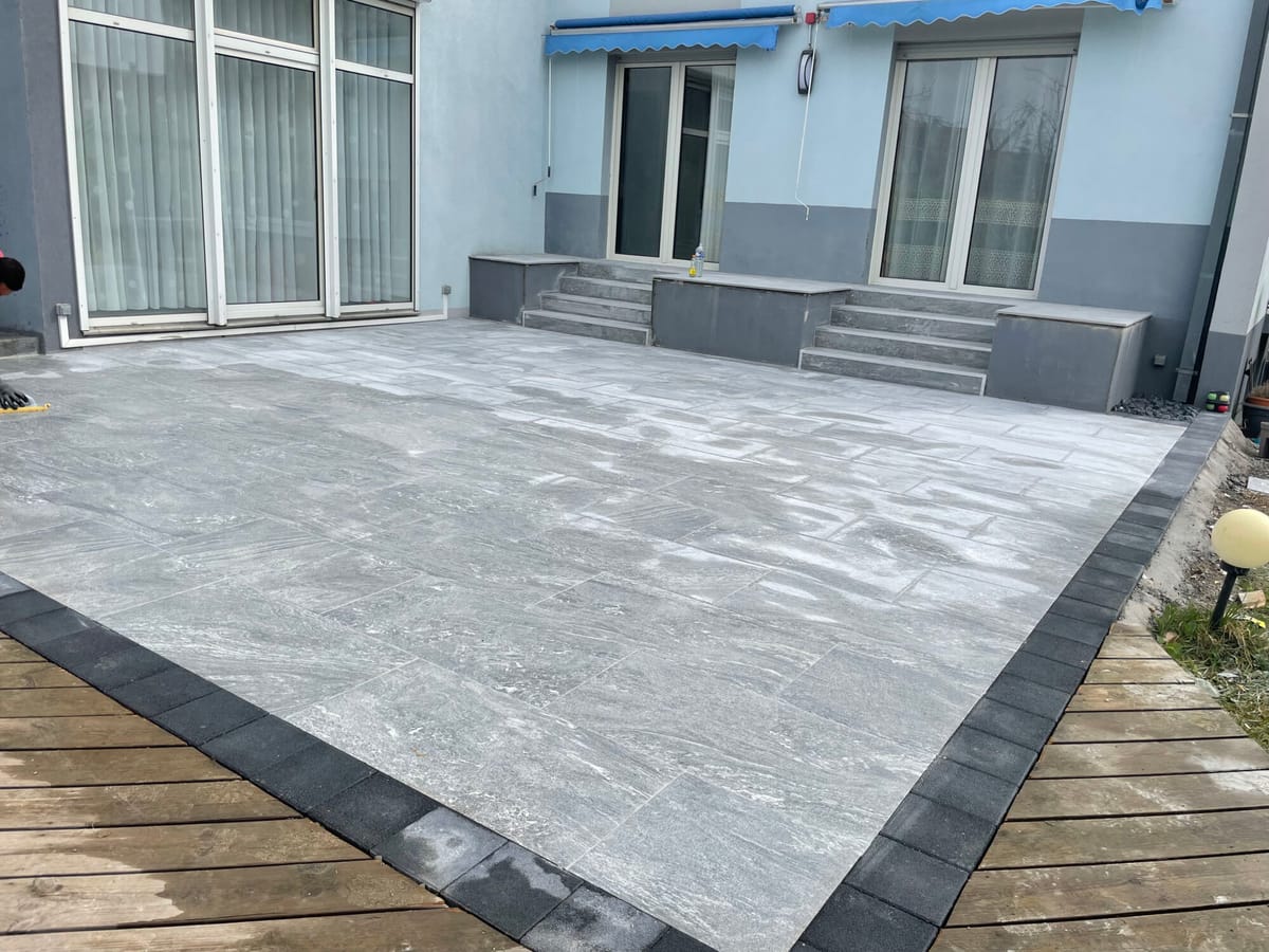 Terrasse en dalles grand format posée le long d'une maison